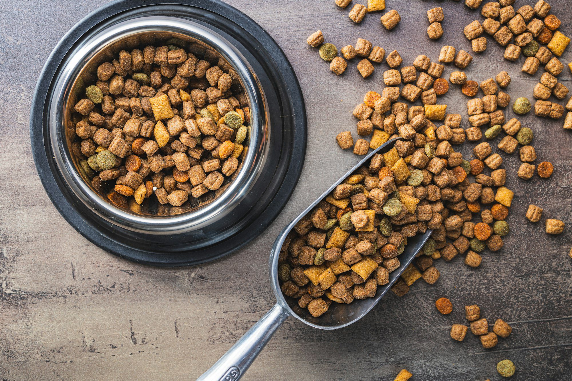 Dry kibble pet food. Dog or cat food on old table. Top view.